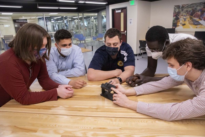 From left, Tim Hafke, Michael Higgins, Michael Stanek, Gabriel Osei and Matthew Heitner work
on their mechanical engineering senior project at the Fabrication Lab inside the Engineering Building.