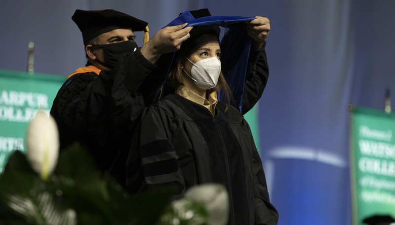 Professor of Systems Science and Industrial Engineering Mohammad Khasawneh hoods Maryam Soltanpour Gharibdousti at one of two Doctoral Grad Walks held May 13.