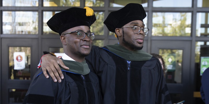 Two members of Binghamton University's School of Pharmacy and Pharmaceutical Sciences inaugural class at their Commencement in May 2021.