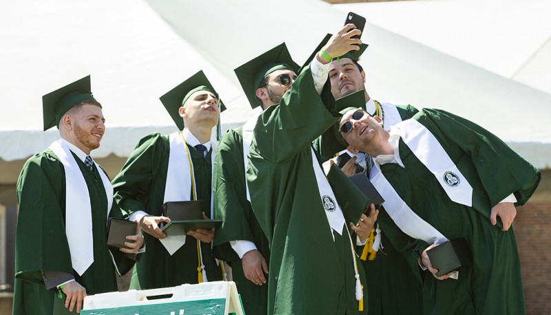 A group of School of Management graduates grab a selfie before processing into the Events Center for their Grad Walk.