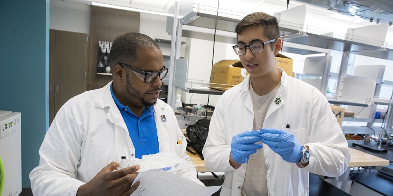 Tony Davis, assistant professor of pharmaceutical sciences, speaks with his undergraduate student, Kaiyu Tio.