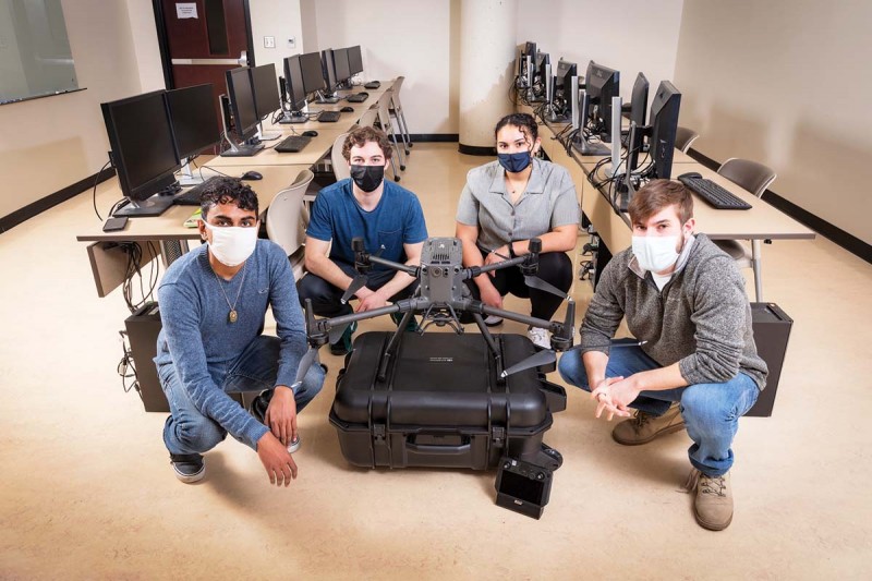 SSIE students, from left, Raj Persad, Will Florio, Jenna-Marie Gaston and Daniel Fee show the drone they will use for their senior project, which involves inspection of solar panels from the air.