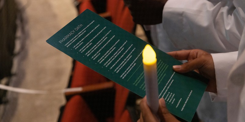 The School of Pharmacy and Pharmaceutical Sciences Class of 2026 participated in its White Coat Ceremony, Aug. 27, in the Anderson Center's Osterhout Concert Theater. Here, a student holds the Light of Knowledge while reciting the Oath of a Pharmacist.