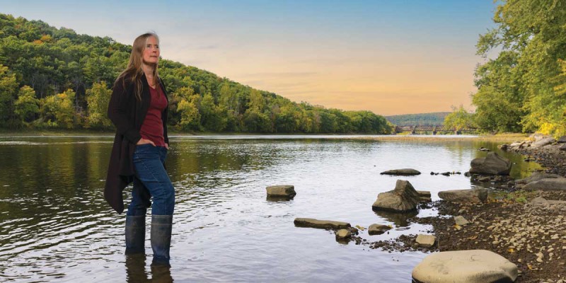 Katie Edwards, assistant professor of pharmaceutical sciences, stands in the Susquehanna River, which can be impacted by pharmaceutical residue discharged into waterways.