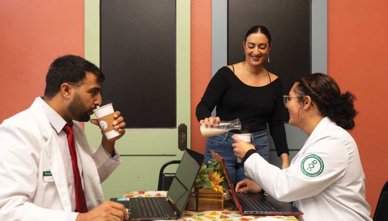The Grapevine Café owner Rita Moelder serves School of Pharmacy and Pharmaceutical Sciences second-year PharmD student Arshad Ali, left, and fourth-year PharmD student Erin Wong as they catch up on coursework.