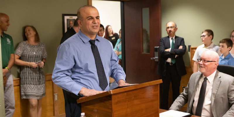 Distinguished Professor and SSIE Department Chair Mohammad Khasawneh speaks in April at the dedication of the Krishnaswami “Hari” Srihari Executive Boardroom in the Engineering Building. Dean Srihari watches in the center background, with Provost Donald Hall seated at right.