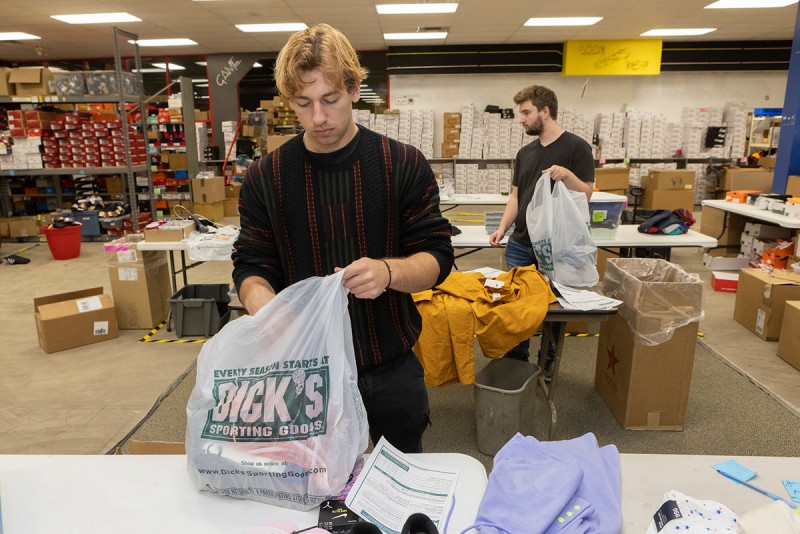 Aigin Hertel-Bernstein '23 and Tyler Lounsbery '23 pack orders at Locker Room 345, a Binghamton-area charity that distributes clothing donated by Dick's Sporting Goods to low-income students.