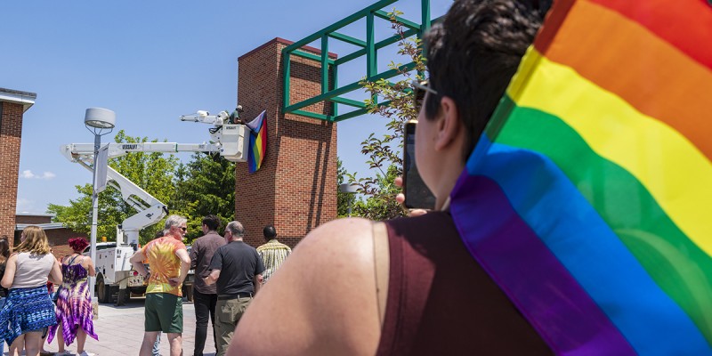Members of the Binghamton University community participated in a Progress Pride flag raising ceremony to kick off Pride Month, June 1, 2023. Officials from the Q Center; Division of Diversity, Equity and Inclusion; and Residential Life lead a short ceremony before James David of Physical Facilities hung the flag on a University Union wall.