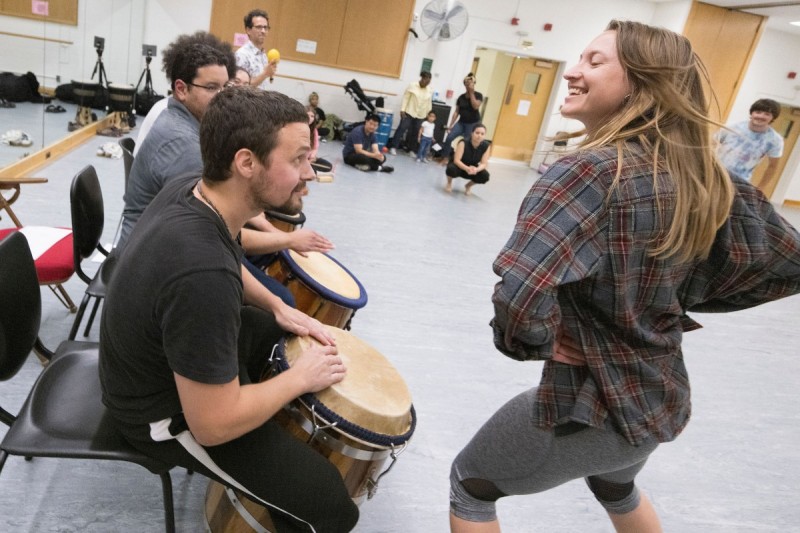 Keaton Rood ’10, MA ’15 drums as his wife Miranda '10 dances during a workshop on traditional Puerto Rican Bomba drum and dance music Sept. 1, 2023.