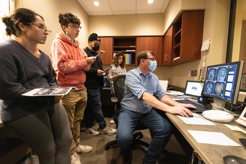 J. David Jentsch, Distinguished Professor and Chair of Psychology, left, shows neuroscience laboratory students the different parts of the brain at the new magnetic resonance imaging (MRI) center in the United Health Services (UHS) building off campus, October 9, 2023.