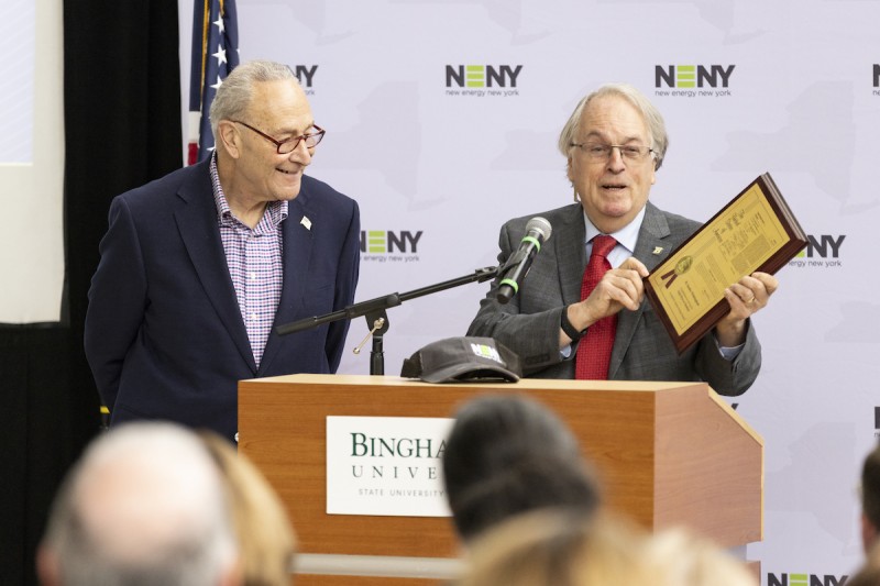 M. Stanley Whittingham, Nobel Laureate and distinguished professor of chemistry, shows his framed patent for the lithion-ion battery while greeting U.S. Senate Majority Leader Chuck Schumer during a U.S. National Science Foundation (NSF) Regional Innovation Engines announcement on Jan. 29 at Binghamton University.