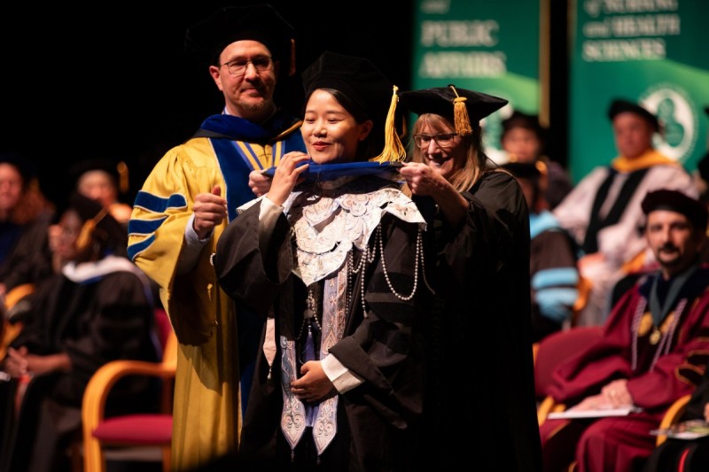 A doctoral candidate receives her hood during the Doctoral Hooding ceremony on May 15, 2025.