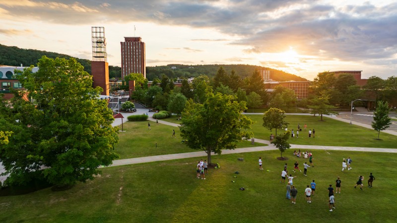 First-year students attending orientation enjoy ice cream and play yard games on the Peace Quad at sunset in July.