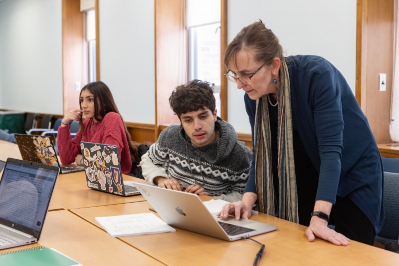 Associate Professor of History Wendy Wall discusses a Broome County property deed with Sharif Zaky, with Jade Torres in the background.