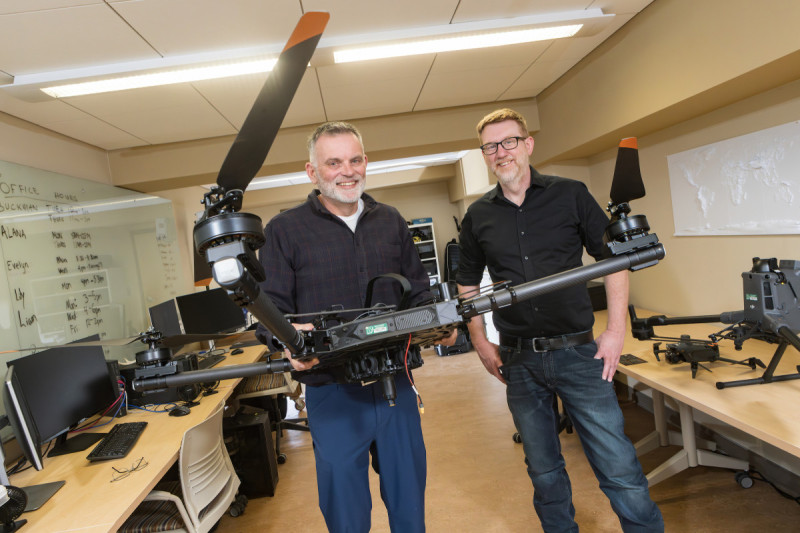 Anthropology Professor Carl Lipo (left) and Geography Professor Thomas Pingel in Pingel's lab, with drones and LiDAR equipment.