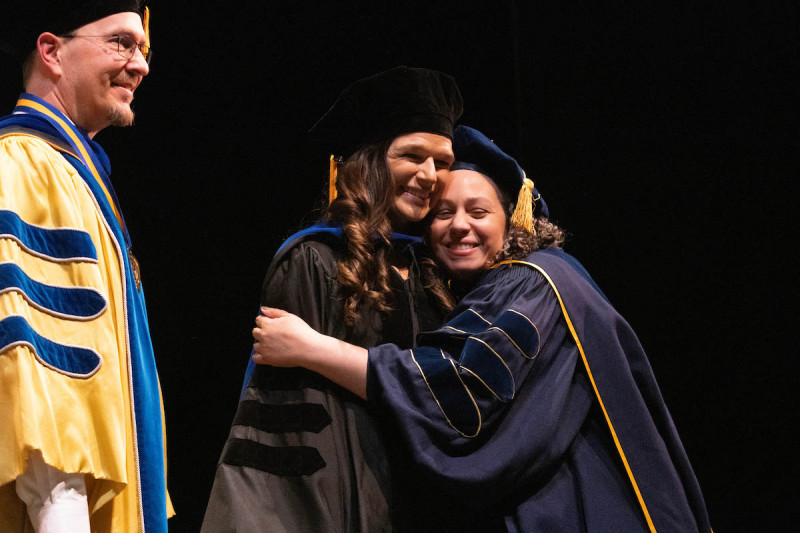 A doctoral candidate hugs her advisor onstage during the hooding ceremony on Thursday, May 14.