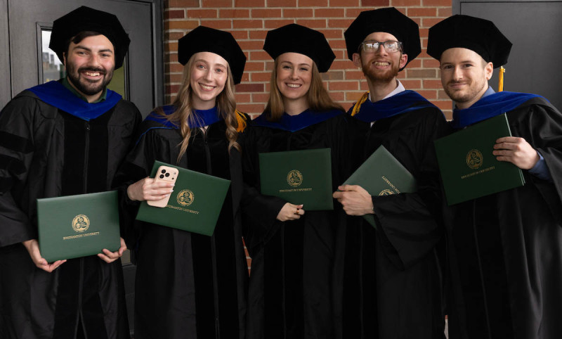 Newly minted PhDs celebrate after Thursday's doctoral hooding ceremony.