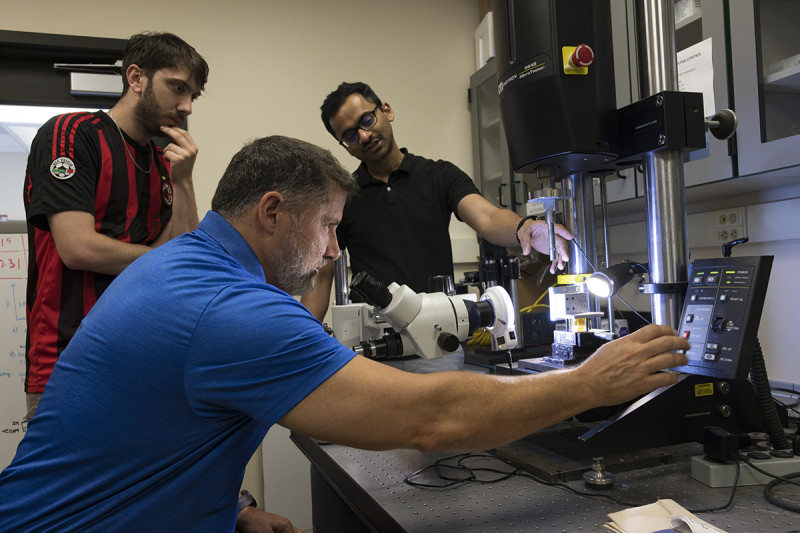 Zach Schinasi '22, MAT '23, left, and Gene Jordan, center, test electronics reliability with Sai Kiran Reddy Munnangi, a PhD student in the School of Systems Science and Industrial Engineering, at Professor of Empire Innovation Peter Borgesen's lab at Binghamton University's Innovative Technologies Complex. Schinasi and Jordan were part of the Research Experiences for Teachers program.