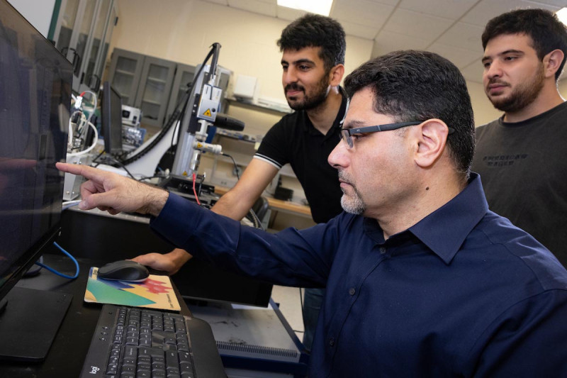 Professor Mohammad Younis works with PhD students Hasan Albatayneh, left, and Basil Alattar at his lab in the Engineering and Science Building at the Innovative Technologies Complex.
