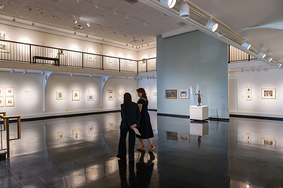 Binghamton University Art Museum Director Diane Butler shows some of the museum's works in the second-floor gallery to President Anne D'Alleva.