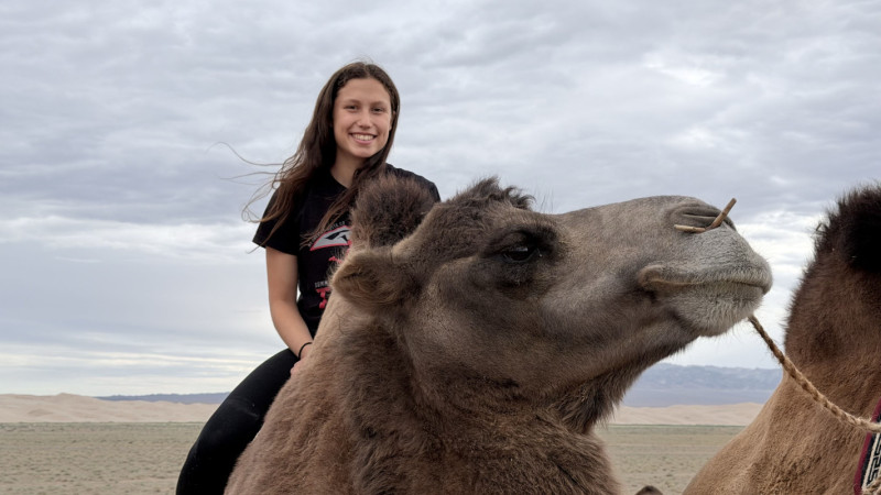 Junior Ariel Esposito rides a camel in the Gobi desert.