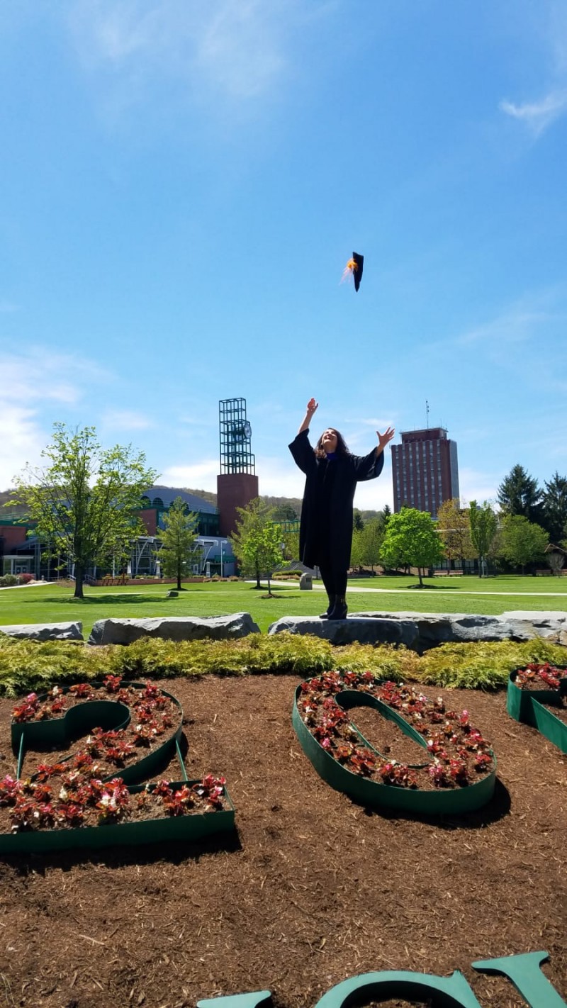 Rania Said, who earned her PhD in comparative literature in May 2020, celebrates on the Binghamton University campus in her graduation gear.