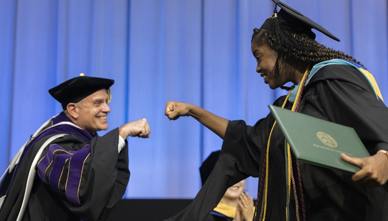 Vice President for Student Affairs Brian Rose congratulates College of Community and Public Affairs graduate Kamryn Scott with a fist bump during the noontime Commencement ceremony.
