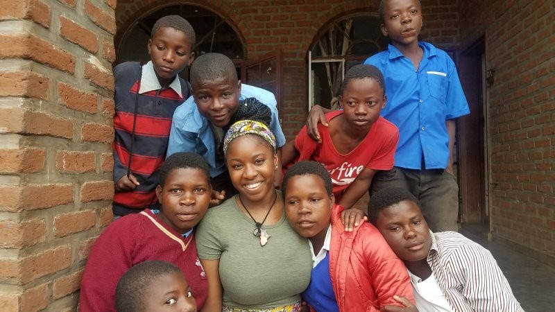 Binghamton University MSW student Eboniqua Smith works with students of the Malawi Children's Mission.