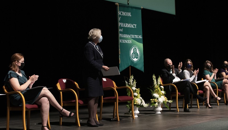 Gloria Meredith, founding dean of the School of Pharmacy and Pharmaceutical Sciences, is applauded during a tribute to her during the school's fifth, and her final, White Coat Ceremony.
