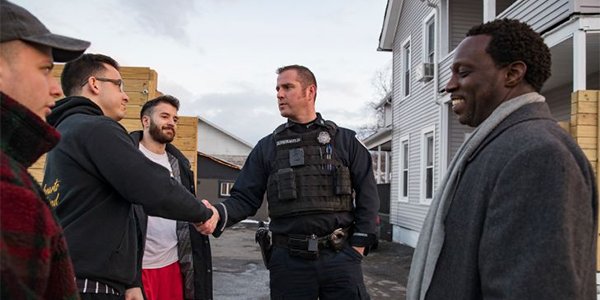 Binghamton City Police Officer Chris Governanti shakes hands with city residents as Binghamton University's Interim Dean of Students Randall M-J Edouard looks on.