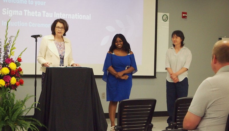 Nicole Rouhana, associate professor of nursing and director of graduate nursing programs, presents the Grace L. Penny Memorial Award to recipients Gifty Amofa (left) and Young Kim.