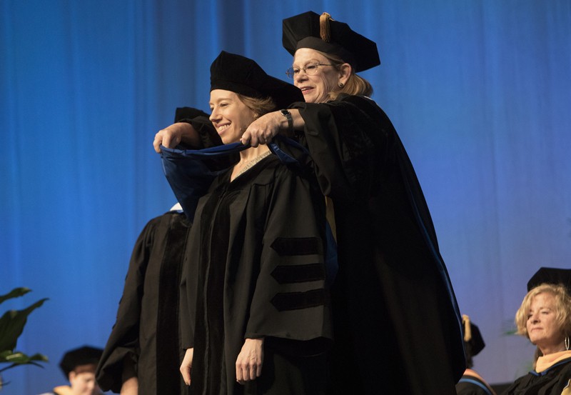 Beth Polzin, who received her doctorate in comparative literature on May 19, is hooded by Susan Strehle, dean of the Graduate School.