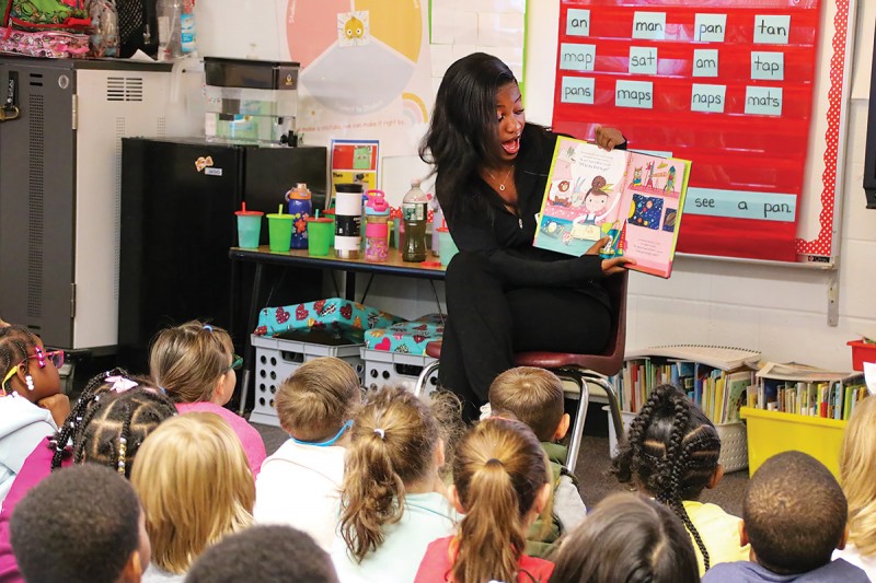 National Society of Black Engineers member Angel Okoro reads to students at Horace Mann Elementary School in Binghamton as part of the group's outreach program.