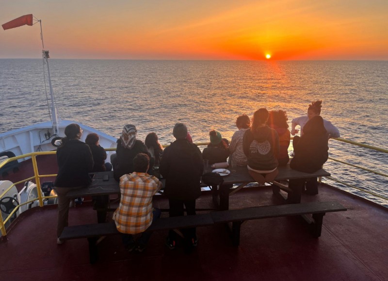 Voyagers watch the sunset aboard the JOIDES Resolution, a deep-sea research vessel.