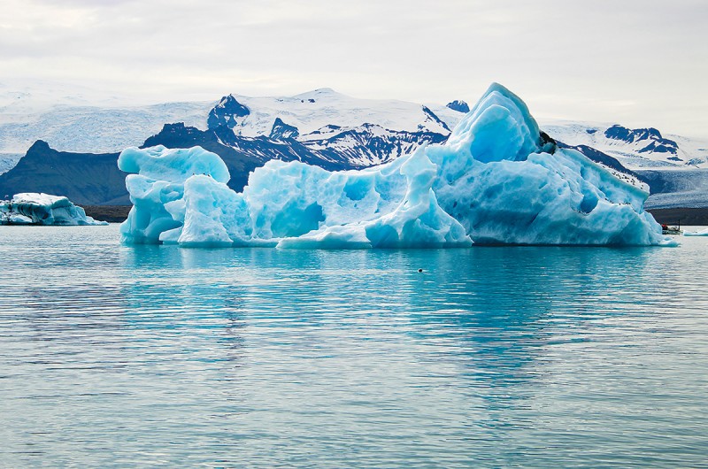 A glacial lagoon with a small ice floe in the foreground,