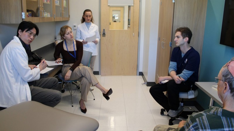 Students from Binghamton University School of Pharmacy and Pharmaceutical Sciences and Upstate Medical interview a patient volunteer.