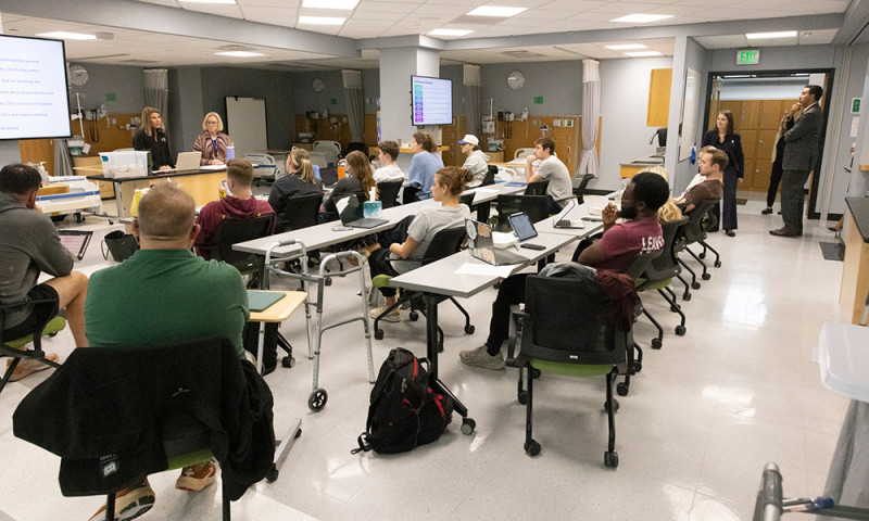 Chancellor King and President D'Alleva stopped by a physical therapy discussion and simulation exercise on mobility, focusing on weight-bearing status and assistance levels.