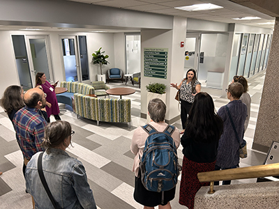 Dean of Libraries Andrea Falcone showcases the newly renovated third floor of Bartle Library to visiting workshop guests.