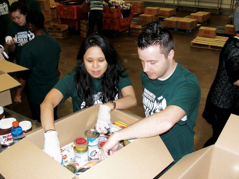 Carol Luong '08, MBA '09, and co-founder Matthew Martindale volunteer at a food pantry during the Alumni Global Day of Service in 2015.