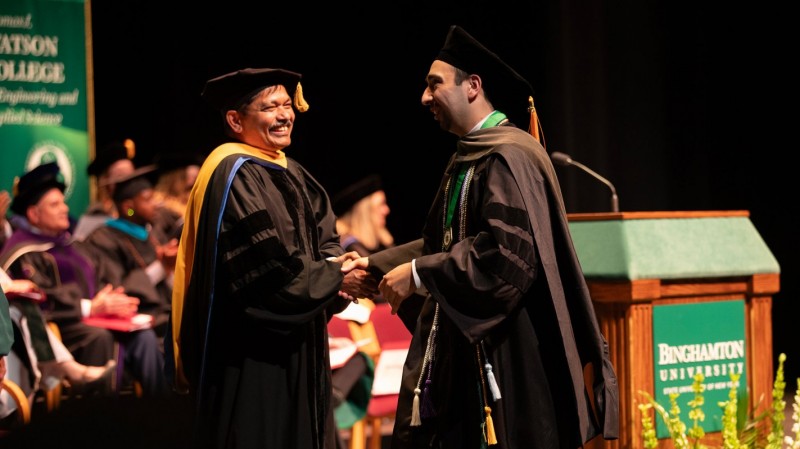 Dean and SUNY Distinguished Professor Kanneboyina Nagaraju congratulates Doctor of Pharmacy graduate Nicholas Lukan.