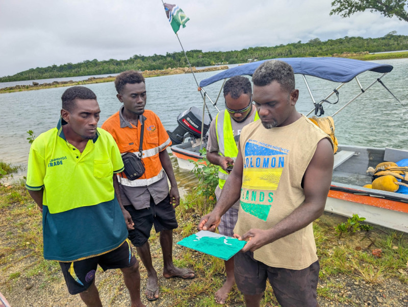 Solomon Islanders view a 3D-printed topographic map of New Georgia Island.