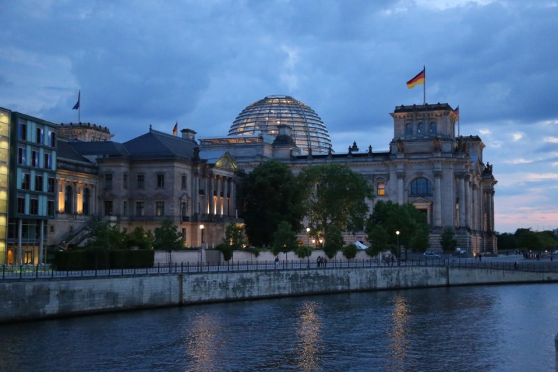 The Reichstag building seen at night in Berlin, including its illuminated dome.