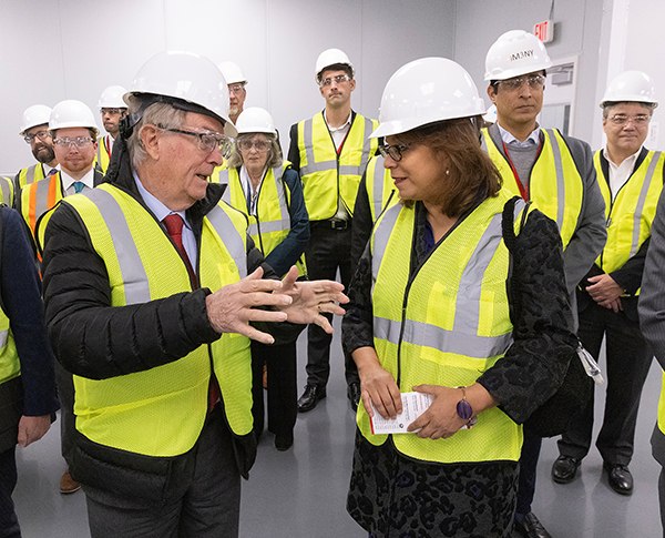 Alejandra Y. Castillo, assistant secretary of commerce for economic development, talks with Nobel Prize laureate M. Stanley Whittingham during a New Energy New York tour of iM3NY's Gigafactory in October 2022.