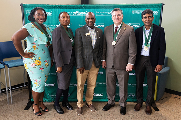 Matthew Winston Jr., center, executive director of alumni engagement, stands with the alumni distinguished-service medal recipients. From left are: Taris T. Rodney, Simone Sterling, Tim Kelly and Subhachandra Chandra.
