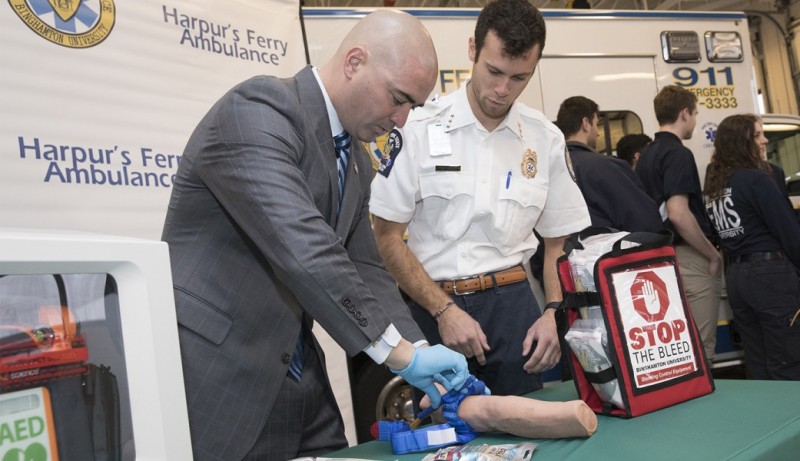 Stephen Baumgarten, executive director of Harpur's Ferry student-run volunteer ambulance service, shows New York Sen. Fred Akshar how to apply a tourniquet to staunch bleeding.