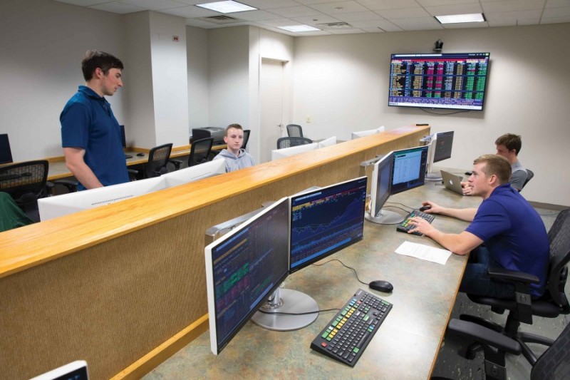 Students in the Zurack Trading Room discuss various companies and their potential for stock trades as they make decisions for the Binghamton University Zurack Trading Room and Investment Fund.