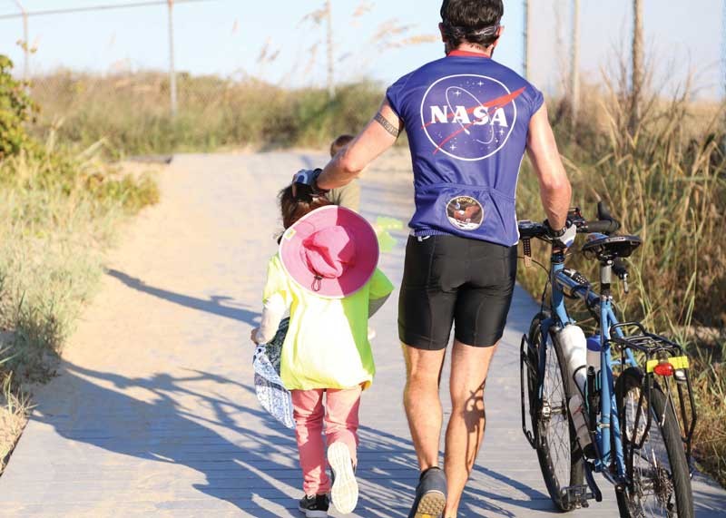 James Warner, accompanied by his niece, Lucy, walks to the beach to dunk his bicycle tires into the Atlantic Ocean upon his return to Virginia Beach.