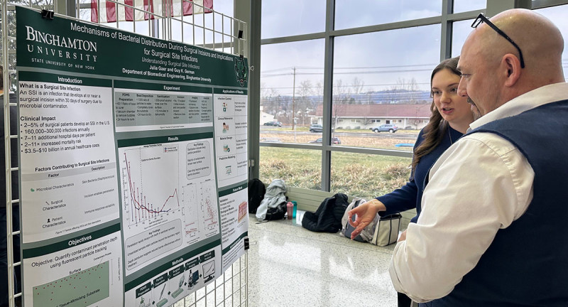 Student Julia Gaer discusses her work with Associate Professor Guy German at the fifth annual Biomedical Research Expo on March 20.