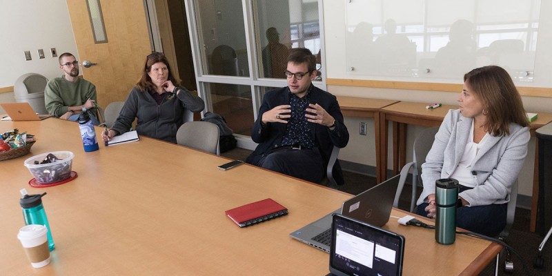 Assistant Professor Matthew Uttermark, center, speaks during a Lunch & Learn discussion among students and faculty in the CRA program.