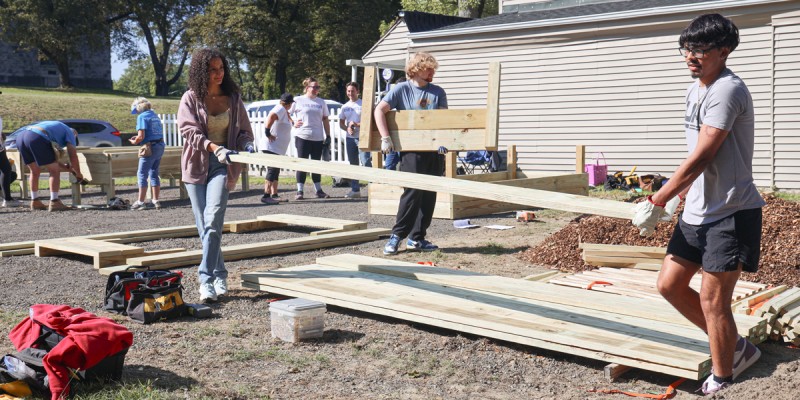 Students move materials to build garden beds at a VINES volunteer project in Johnson City.